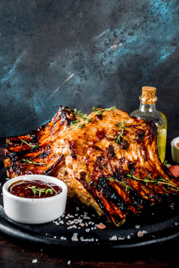 Deliciously cooked Instant Pot BBQ ribs, with a smoky glaze and a side of coleslaw, served on a platter. The ribs are perfectly browned and glistening with barbecue sauce