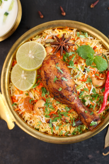 A tantalizing serving of Instant Pot Biryani, a classic Indian rice dish, presented in a white bowl. Fragrant basmati rice is beautifully layered with seasoned meat or vegetables, garnished with saffron-soaked milk, and sprinkled with fresh herbs. This aromatic dish embodies the rich and complex flavors of India.